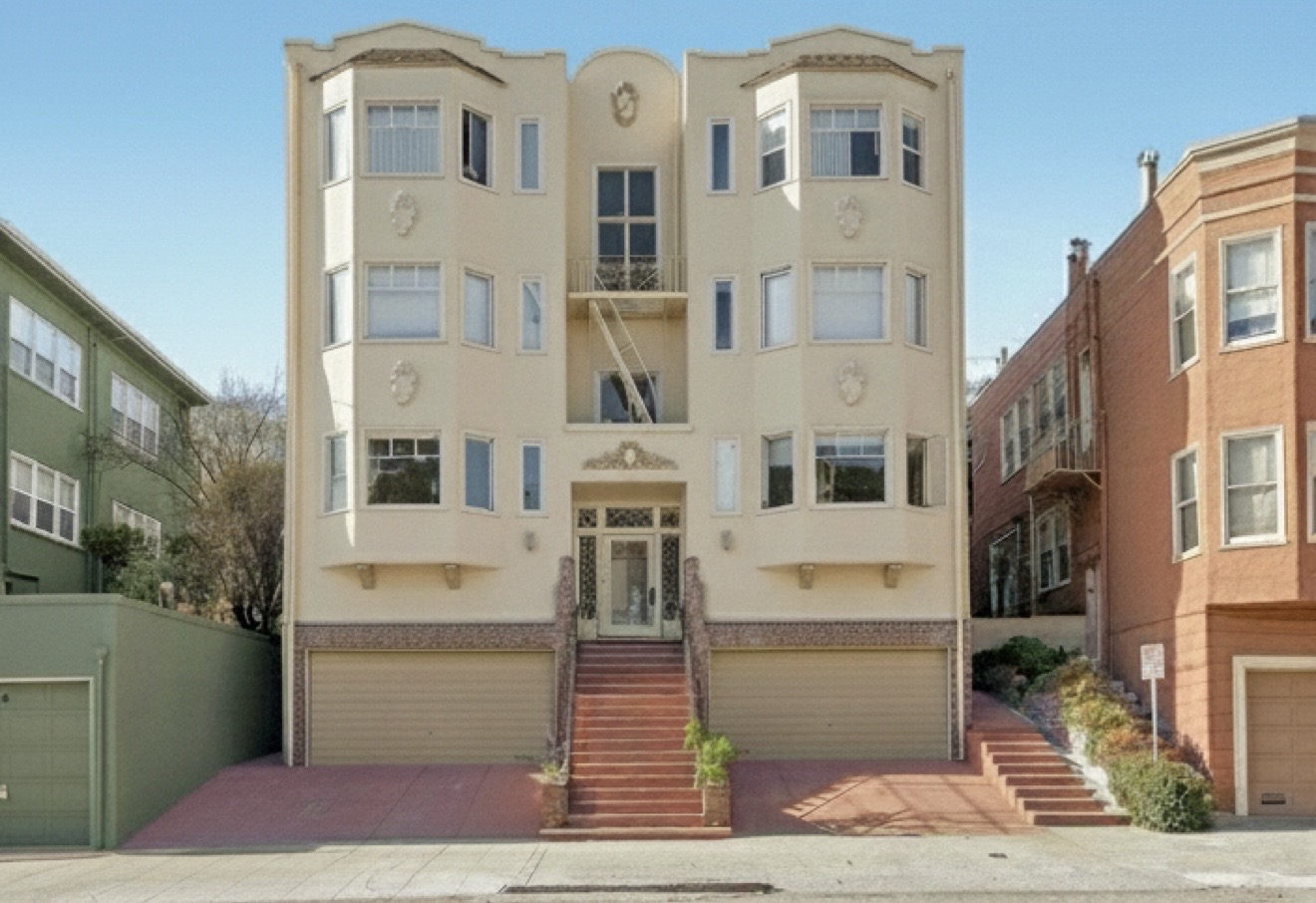 Front elevation of a multifamily apartment building with central staircase and garages.